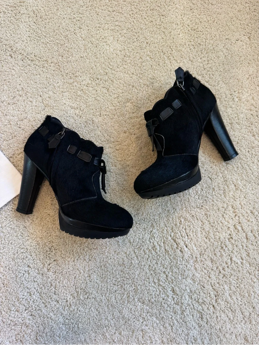 ZORAIDE black calf hair ankle booties with leather strap and tassel accents.